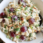 Chicken salad with grapes and herbs in a rustic serving bowl