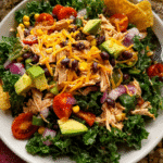 Chicken taco salad with kale and avocado in rustic bowl