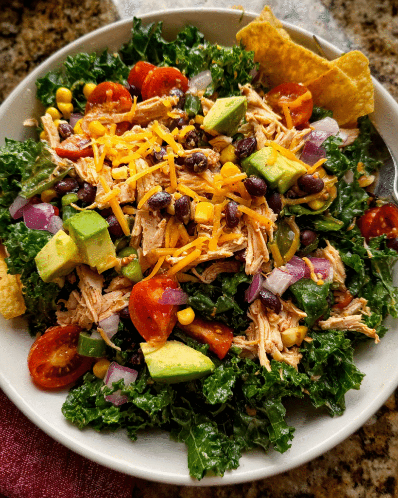 Chicken taco salad with kale and avocado in rustic bowl