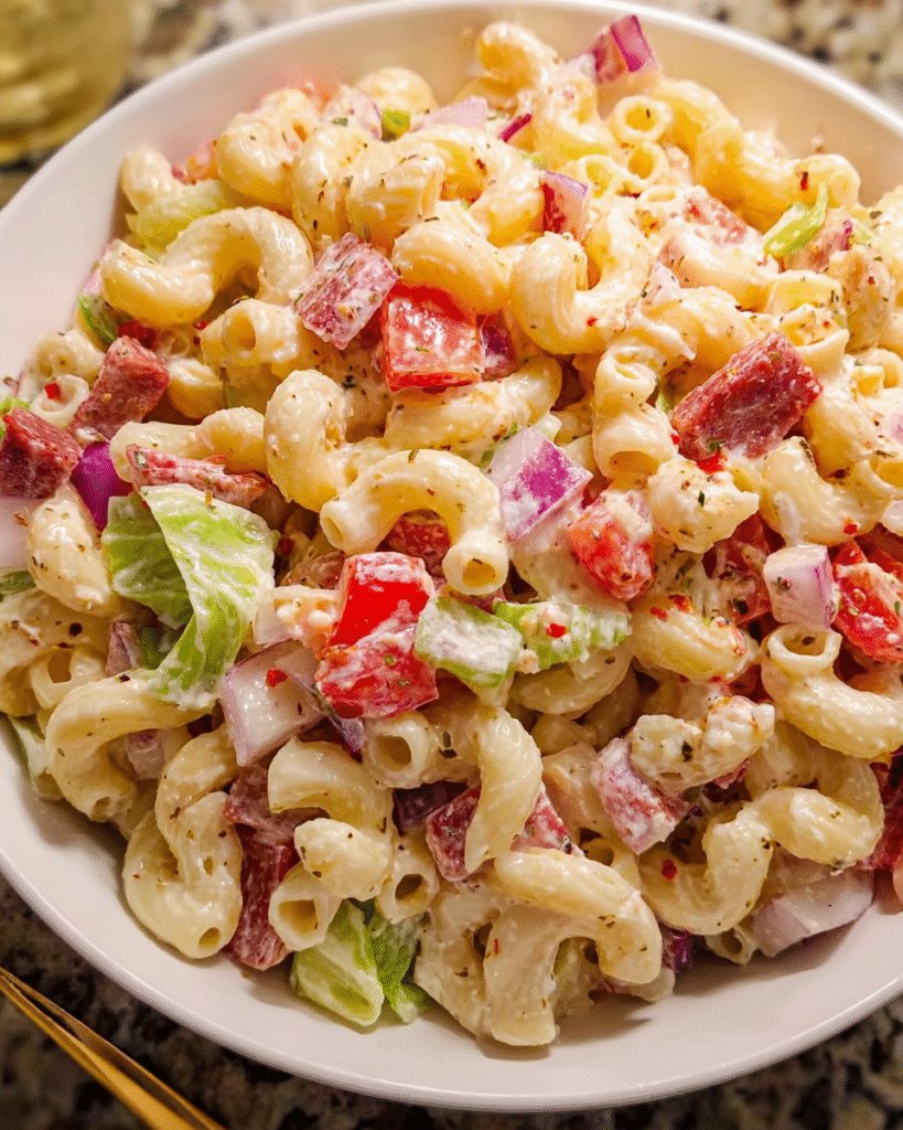 grinder pasta salad in wooden bowl with ingredients