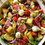 Antipasto salad in rustic bowl with meats, cheese, and greens