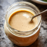 Creamy balsamic dressing in a jar with ingredients