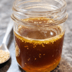Sesame vinaigrette in glass jar with fresh ingredients