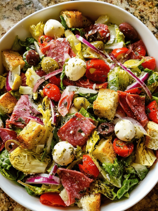 Antipasto salad in rustic bowl with meats, cheese, and greens