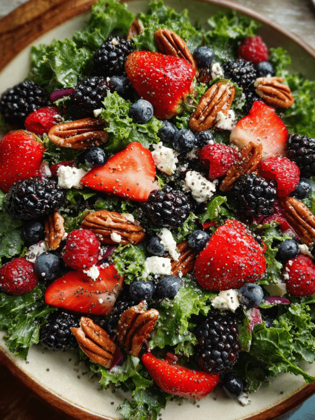 Mixed berry kale salad with lemon poppy seed dressing in white bowl
