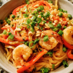 Thai Peanut Sauce Noodles with Shrimp in a bowl with vegetables and creamy peanut sauce