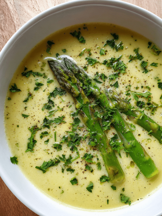 Creamy asparagus soup in bowl with garnish