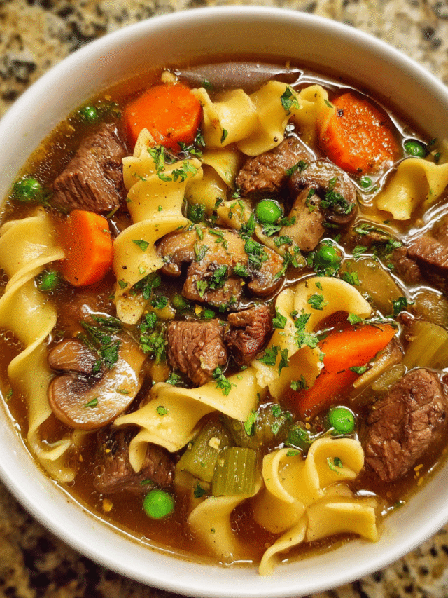 Bowl of beef noodle soup with parsley garnish in rustic setting