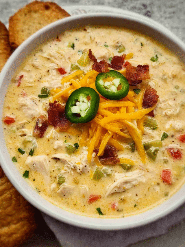 Bowl of creamy jalapeno popper chicken soup topped with sliced jalapeños
