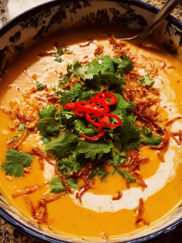 Bowl of Thai Coconut Pumpkin Soup with garnishes and flatbread