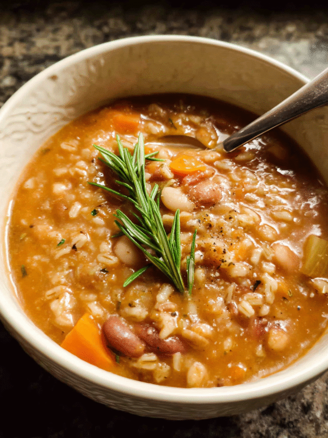 Tuscan farro soup with beans served in a rustic bowl with rosemary
