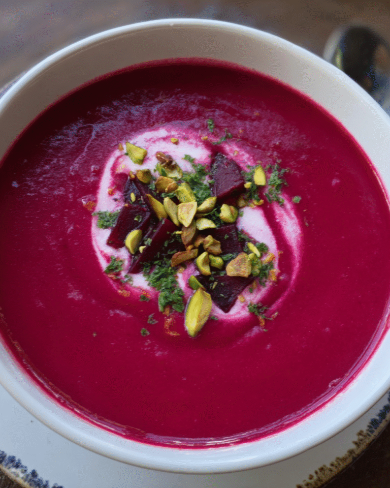 Beet Ginger and Coconut Soup in a bowl with creamy garnish