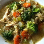 Chicken Broccoli Quinoa Soup in a bowl with broccoli, quinoa, and shredded chicken