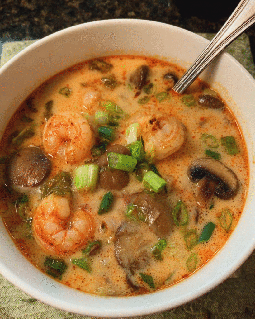 Bowl of coconut lemongrass shrimp soup with herbs
