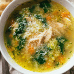 Bowl of kale quinoa chicken soup with lemon and parmesan