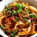 bowl of spicy chili garlic noodles with green onions