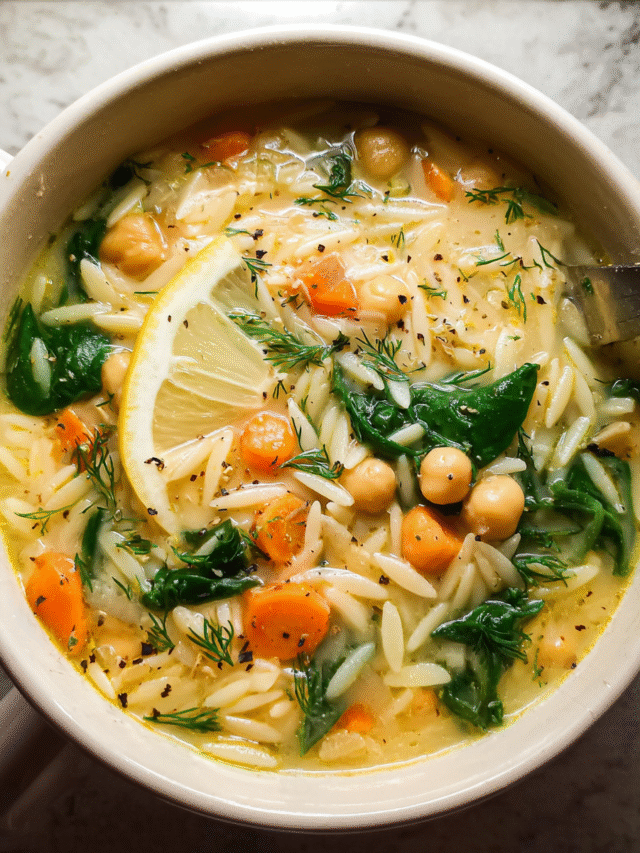 Bowl of Mediterranean lemon chickpea orzo soup with herbs