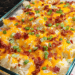 Loaded baked potato casserole with cheddar cheese and green onions