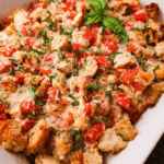 Make-Ahead Bruschetta Chicken Bake topped with stuffing and melted cheese in a white baking dish