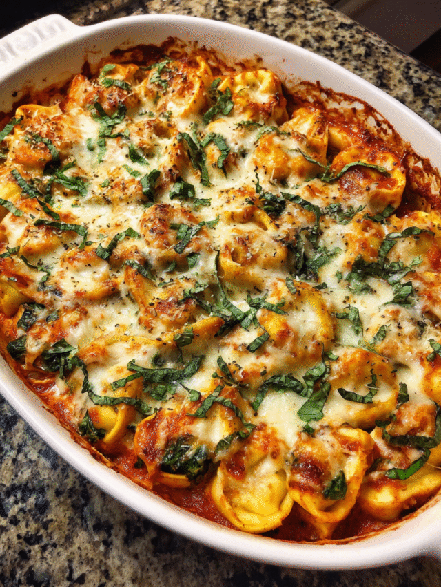 Cozy baked tortellini with spinach in a casserole dish, topped with bubbling cheese and fresh basil