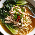 Asian noodle soup with chicken, bok choy, and fresh noodles in a bowl
