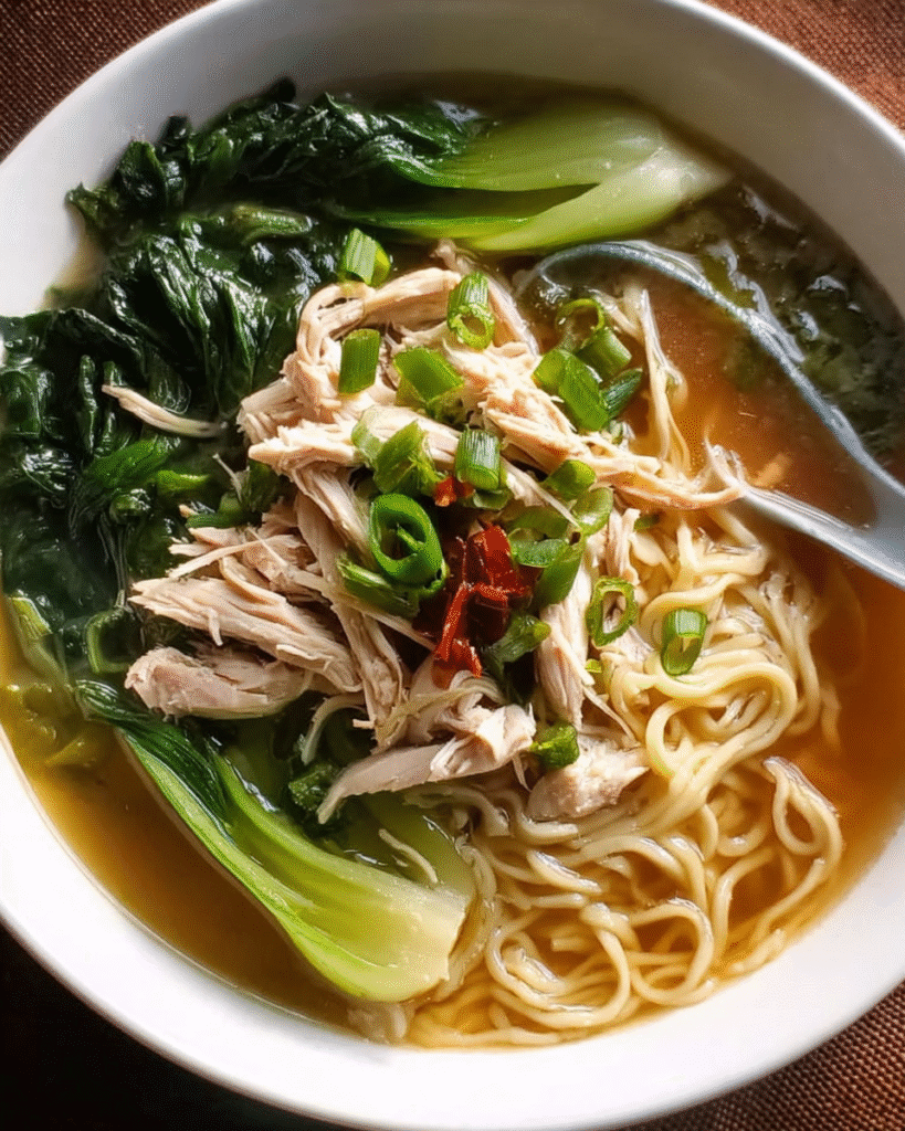 Asian noodle soup with chicken, bok choy, and fresh noodles in a bowl