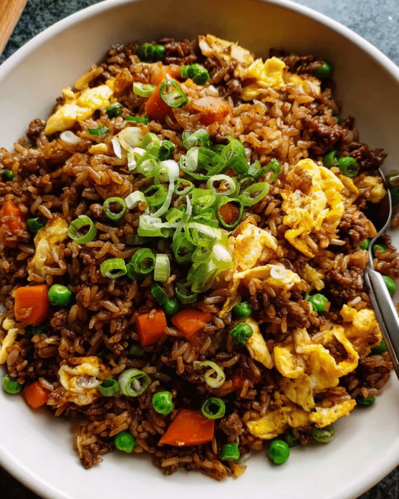 Skillet of homemade beef fried rice with vegetables and scrambled eggs
