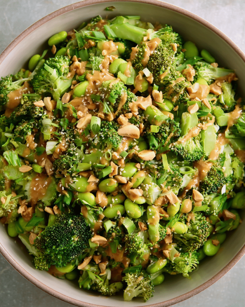 Broccoli Salad with Peanut Sauce in a bowl topped with roasted peanuts and cilantro