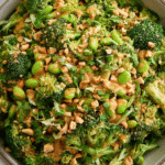 Broccoli Salad with Peanut Sauce in a bowl topped with roasted peanuts and cilantro