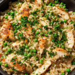 Chicken and rice skillet with peas and parsley in a large pan