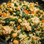 Chicken and spinach rice served in a skillet with fresh greens