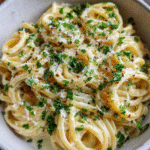 Creamy garlic butter pasta in a skillet with parsley
