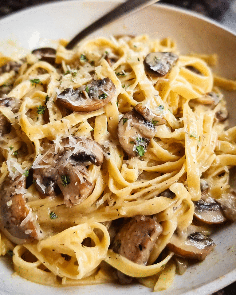Creamy mushroom pasta in a skillet garnished with Parmesan