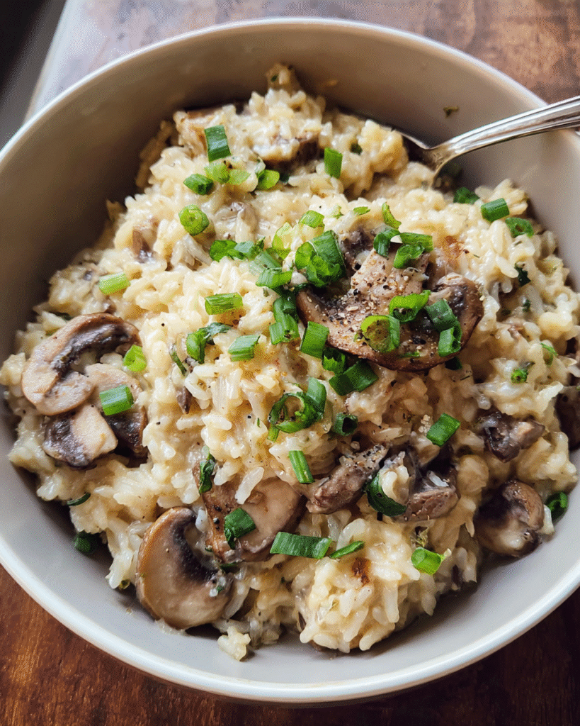 Creamy mushroom rice served in a bowl with green onions