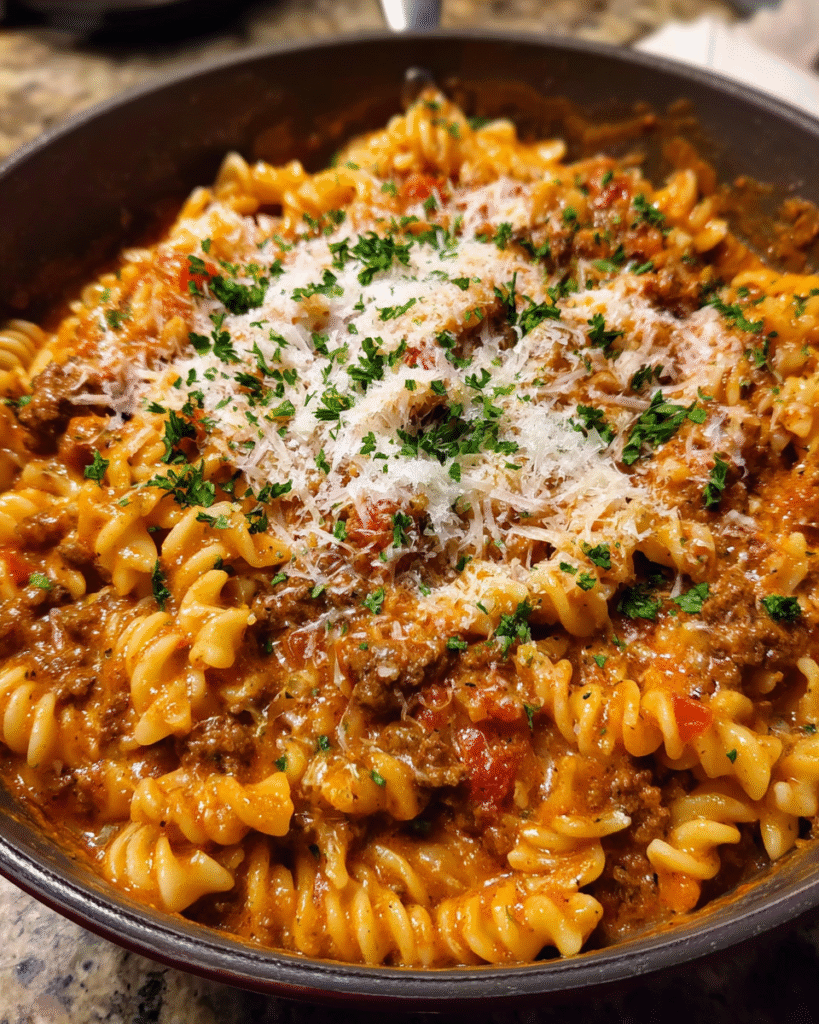 Creamy tomato beef pasta served in a bowl with Parmesan and parsley
