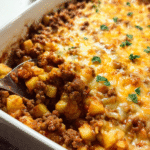 Ground beef and potato casserole topped with melted cheddar cheese