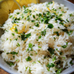 Bowl of lemon garlic herb rice topped with fresh parsley and lemon zest