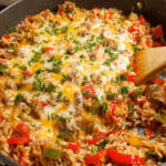 Stuffed pepper skillet with ground beef, rice, and melted cheese in a cast iron pan