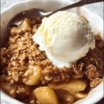 Warm apple crisp dessert with golden oat topping in baking dish
