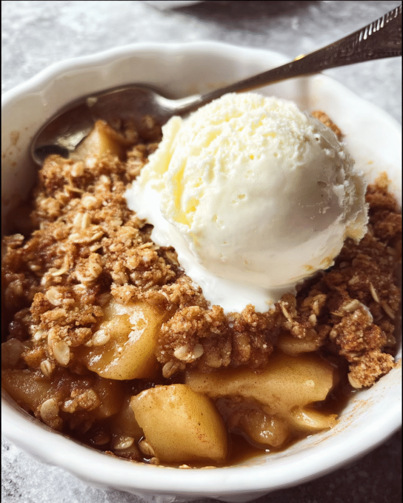 Warm apple crisp dessert with golden oat topping in baking dish