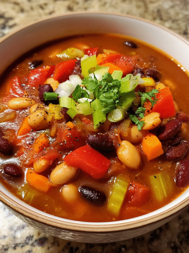 Hearty bean chili soup with black, pinto, and garbanzo beans in a red broth