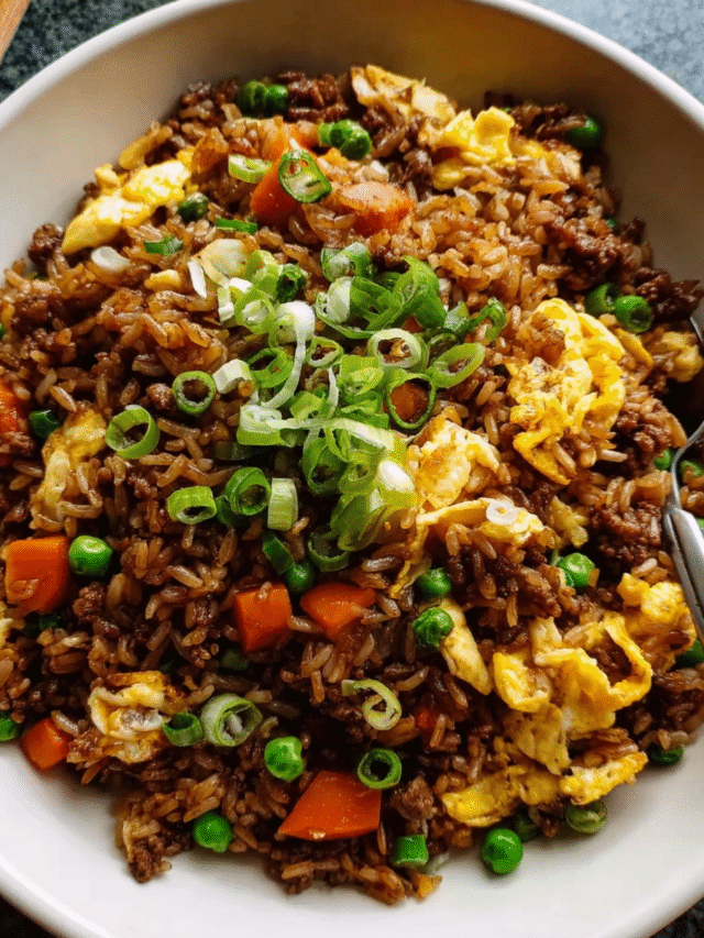 Skillet of homemade beef fried rice with vegetables and scrambled eggs