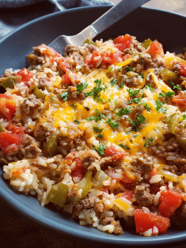 Beef and rice one pan dinner topped with melted cheese in a skillet