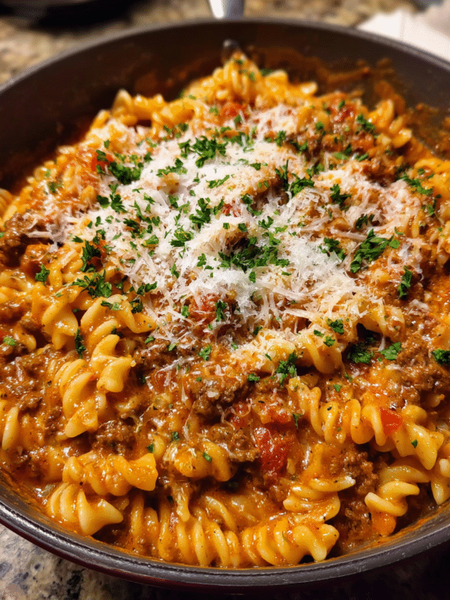 Creamy tomato beef pasta served in a bowl with Parmesan and parsley