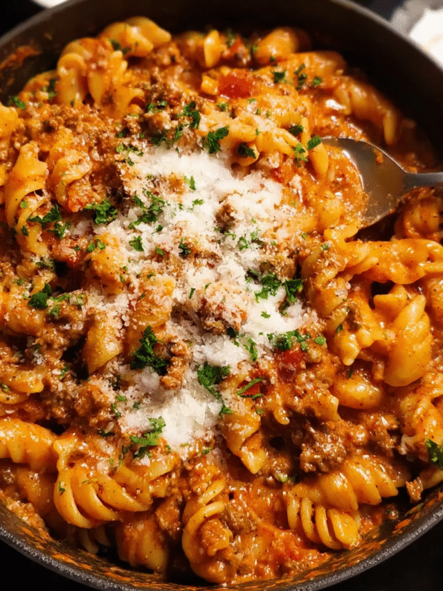 One pot creamy tomato beef pasta in a white bowl with parmesan and parsley
