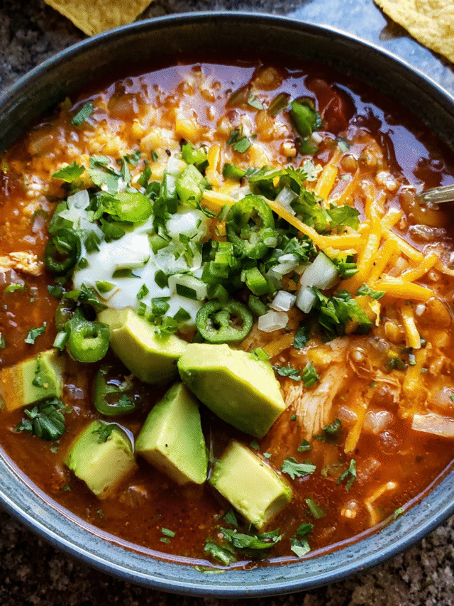 Spicy tortilla soup with chicken and toppings in a bowl