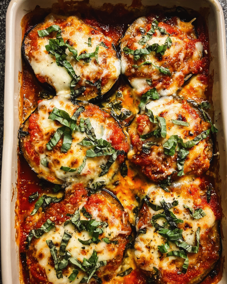 Cheesy layered marinara baked eggplant slices with melted cheese and basil