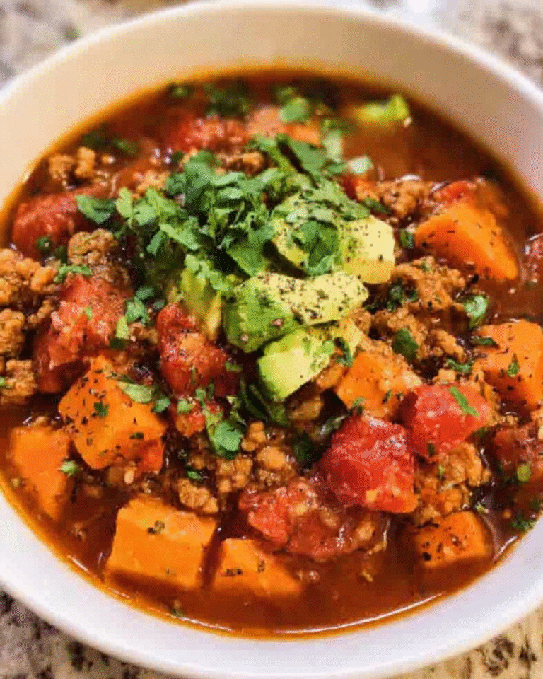 Bowl of chipotle turkey sweet potato chili topped with avocado and cilantro