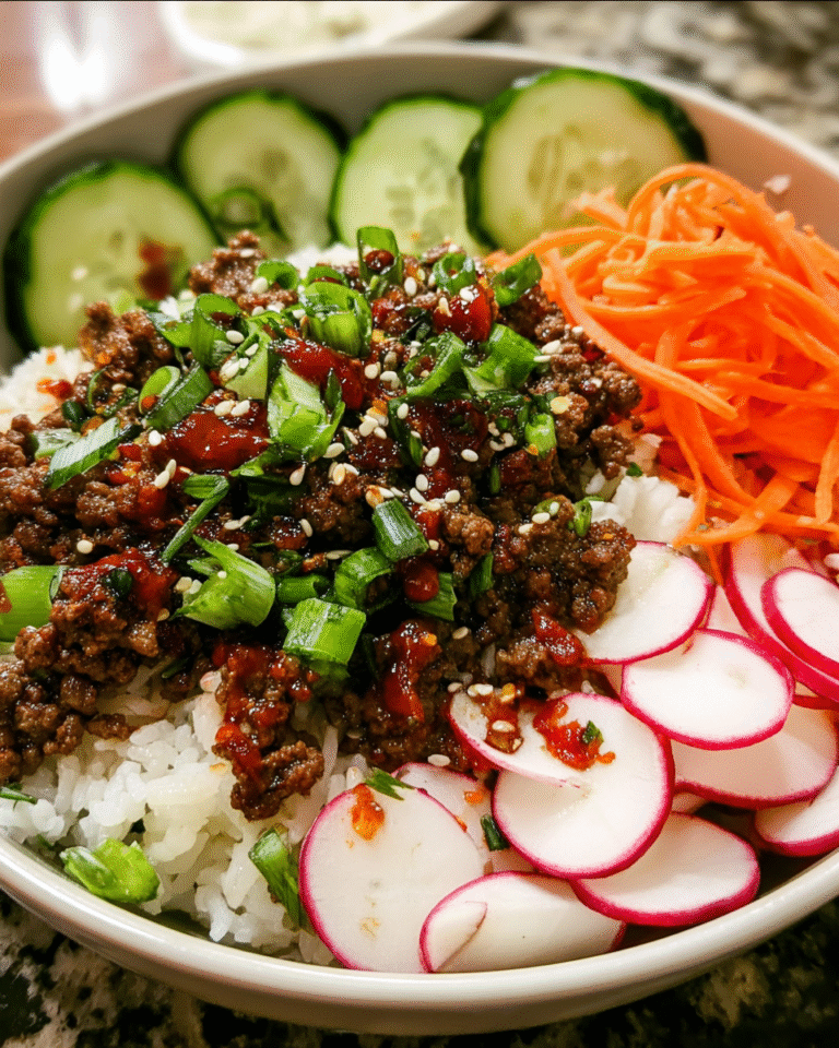 Korean-inspired ground beef bowl with rice, cucumbers, carrots, and sesame seeds
